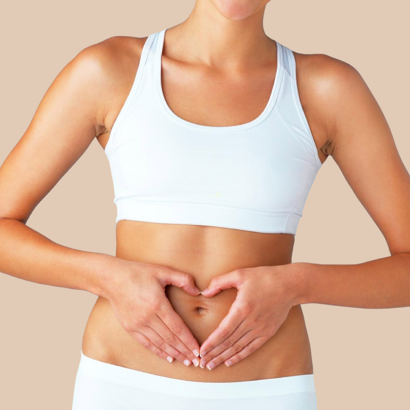Woman in a white sports bra and shorts making a heart shape with her hands on a beige background