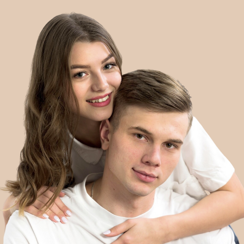 Two people posing closely together against a beige background