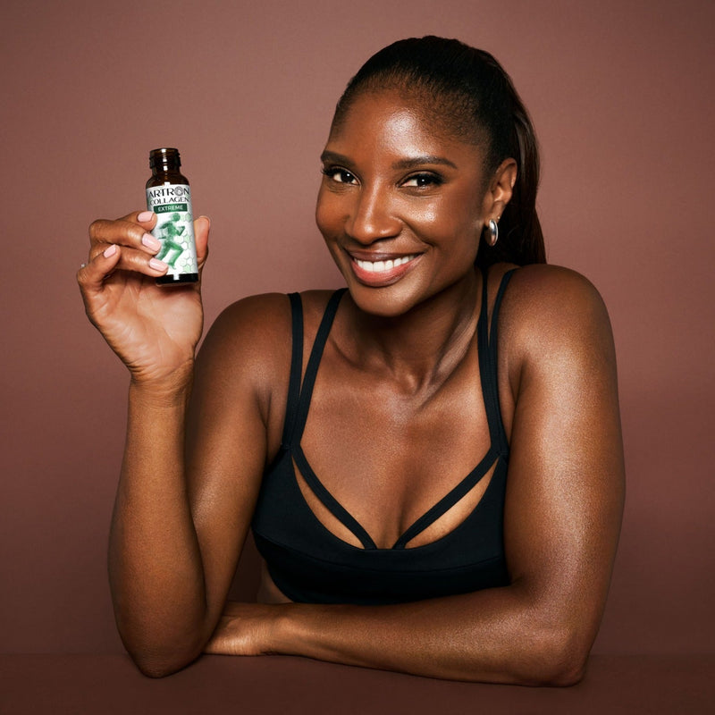 Woman holding a small bottle against a brown background