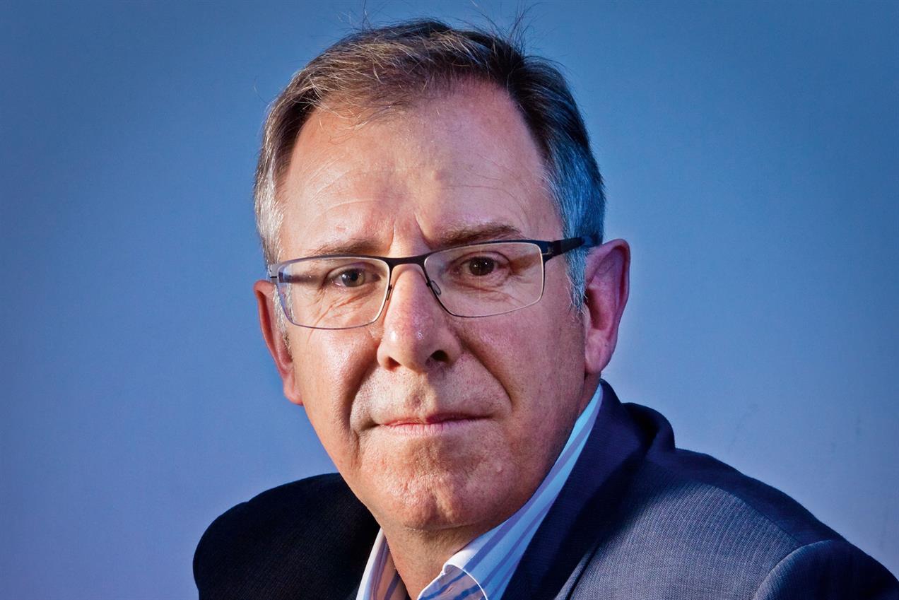 Man wearing glasses and a suit against a blue background