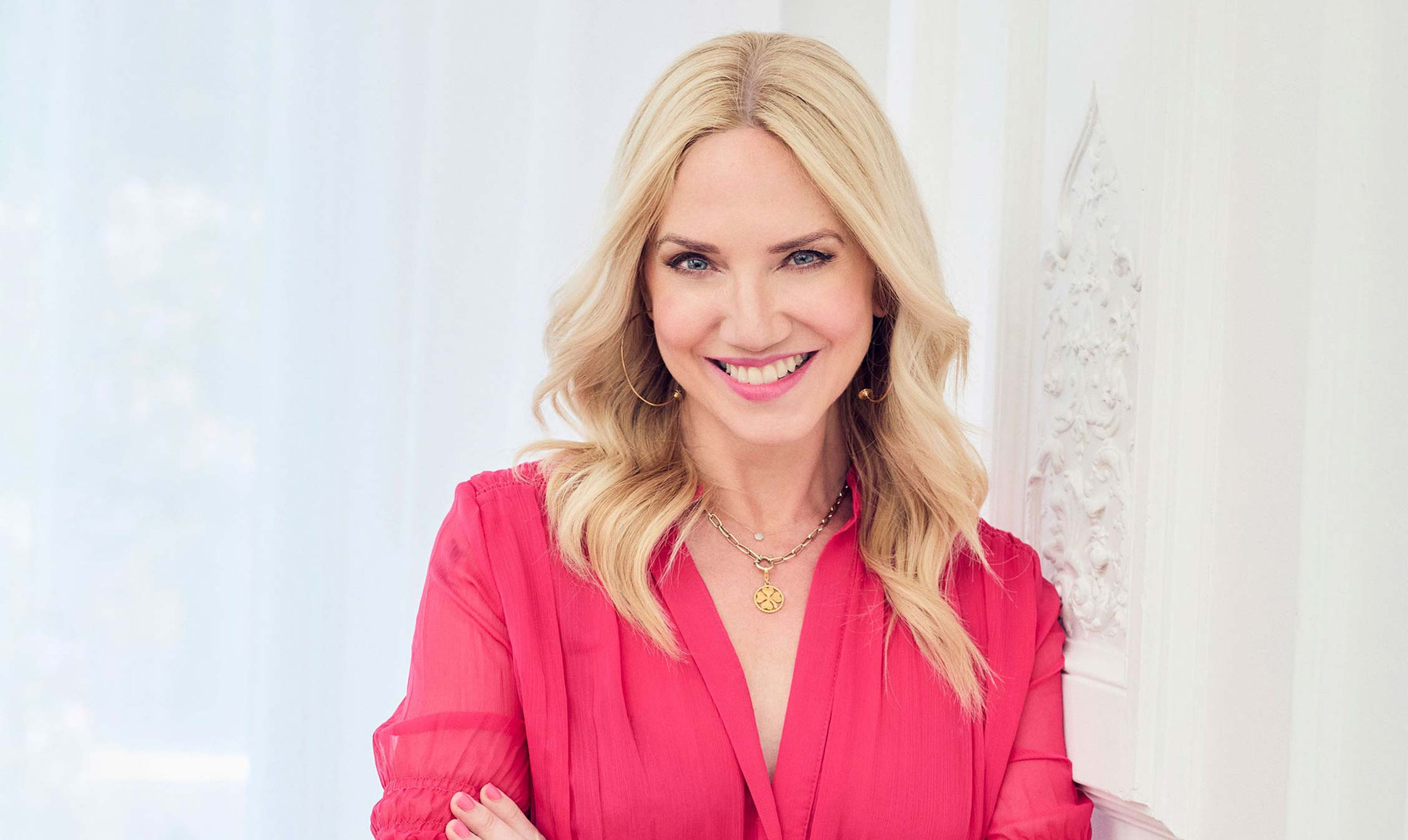 Woman in a pink blouse with a blurred white background
